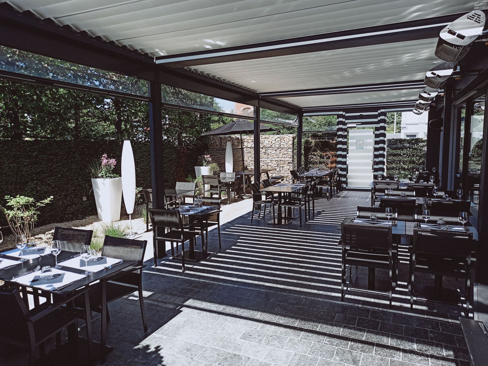 Spacious outdoor dining area with tables, chairs, and ambient lighting.